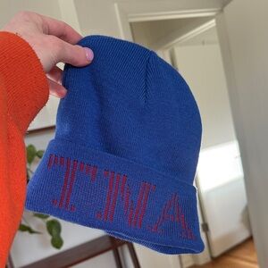 Aria is TNA Blue Knit Beanie with Red Logo